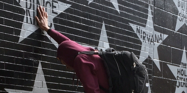Terrance May, a musician who goes by the name May Millions, takes a moment at a growing memorial outside First Avenue, a Minneapolis club where Prince filmed a large portion of his classic movie Purple Rain and recorded several songs on the accompanying album. Photo / AP