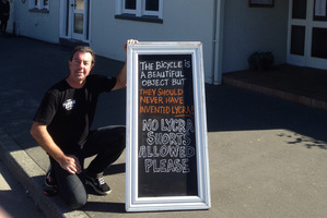 Mike Saunders of The Plough Hotel in Rangiora with his sign banning lycra from the pub.