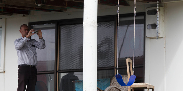 Police take photos of the swing and the chain, at the house at Mangawhai Heads. Photo / Brett Phibbs