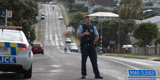 An armed police officer at the cordon on Warspite Avenue in Porirua following the shooting of a police dog. Photo / Mark Mitchell