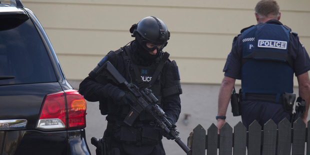 An Armed Offenders Squad member moving into position near the house. Photo / Mark Mitchell