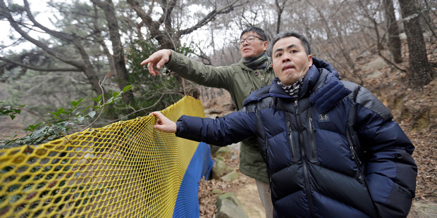 Choi Seung-woo, right, and Lee Chae-sik talk as they walk up a hill behind a row of apartments that was once the Brothers Home in Busan. Photo / AP