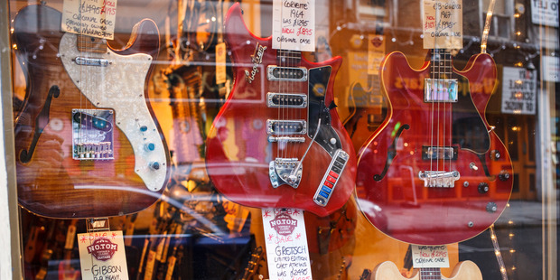 Guitars hang from the walls of the NO.TOM guitar shop on Denmark Street in London. Photo / AP