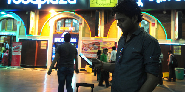 A man uses his phone to buy train tickets at at Howrah Station Howrah, India. Chinese smartphone makers are looking for a big growth in sales in India. Photo / Getty