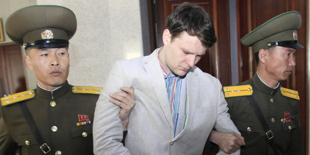 American student Otto Warmbier, center, is escorted at the Supreme Court in Pyongyang. Photo / AP
