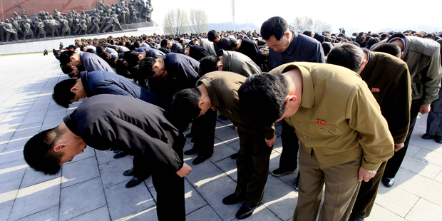 People bow in front of bronze statues of North Korea's late leaders Kim Il Sung and Kim Jong Il at Mansu Hill in Pyongyang. Photo / AP