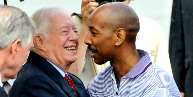 Former U.S. President Jimmy Carter, center left, hugs with American Aijalon Gomes at Pyongyang airport. Photo / AP