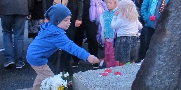 Nat Edhouse, 4, lays a poppy at Waihi's dawn service today. Photo/Melanie Camoin