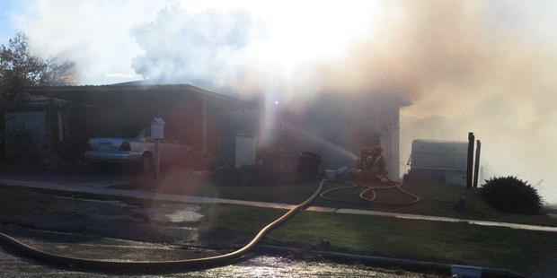 Firefighters work to put out a fire at a house in Te Puke. Photo/Pauline Carney