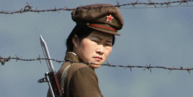 A North Korean soldier looks out from behind a barded wire fence around a camp on the North Korean river banks across from Hekou, northeastern China's Liaoning province. Photo / AP