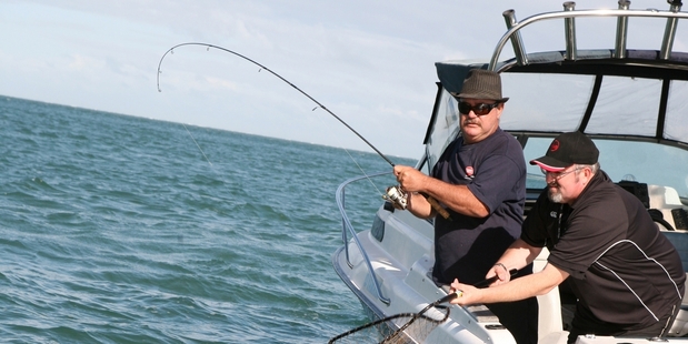 John Bebbington nets a snapper for Keith Patterson on the Kaipara Harbour. Picture / Geoff Thomas