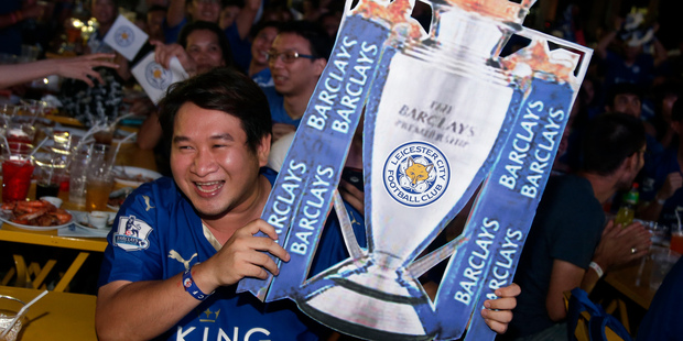 A Thai supporter of Leicester City reacts as people watch the English Premier League soccer match between Leicester City and Manchester United. Photo / AP.