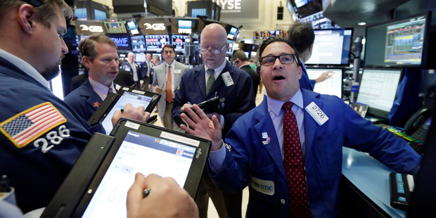 Specialist Paul Cosentino, right, works with traders at his post on the floor of the New York Stock Exchange. Photo / AP