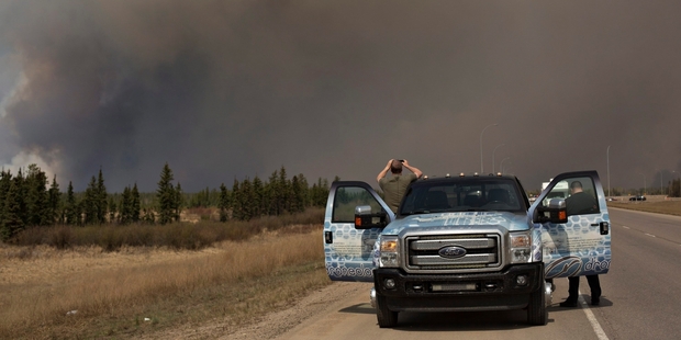 Residents of Fort McMurray escaped the blaze, some stopping to take photos. Pictures / AP