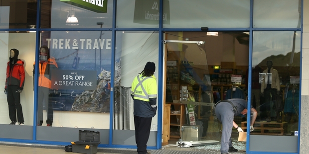 People work to clean up the mess left behind from a ram raid at a Kathmandu store in Fraser Cove Shopping Centre. Photo / John Borren