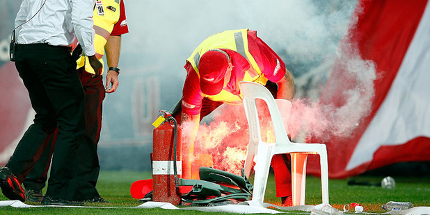 Security staff extinguish a flare during the 2015/16 A-League Grand Final. Photo / Getty