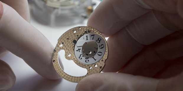 An employee handles the date wheel of a Lange 1 luxury wristwatch during assembly. Photo / Bloomberg