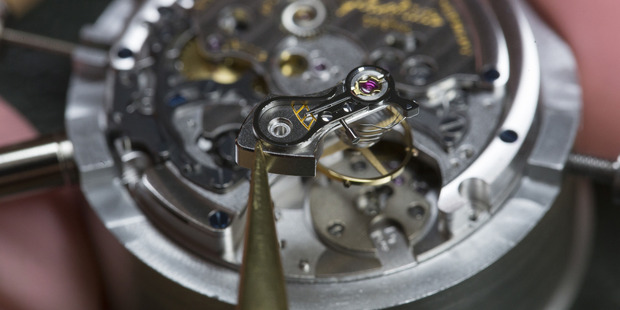 A watchmaker prepares to position an escapement wheel during the assembly of a Senator Chronograph Panorama Date luxury wristwatch. Photo / Bloomberg