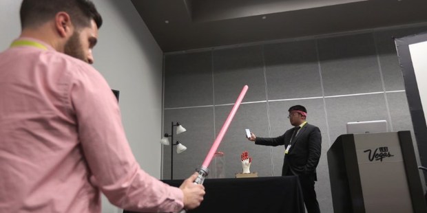 BrainCo CEO Bicheng Han wears the BrainCo Focus 1 to use bio feedback to turn on the light of a Star Wars light saber toy. Photo / AFP