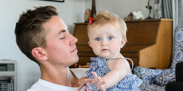Noa Woolloff, 17, with his 9-month-old daughter Kyla in Plimmerton. Photo / Mark Coote.