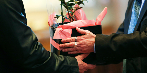 A family member of an organ/tissue donor receives a camellia plant from a donor co-ordinator during a remembrance service for organ donors in Wellington. Photo / Hagen Hopkins