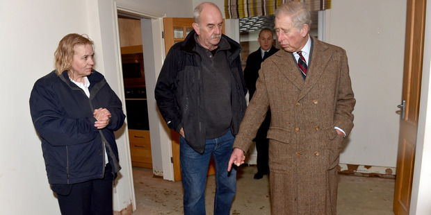 Prince Charles speaks with flood victim Barry Cookson during his visit to homes which were flooded in Carlisle, England. Photo / AP