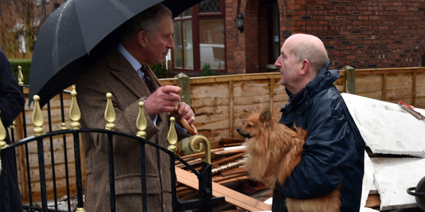 Prince Charles speaks with flood victim Keith Wright during his visit to homes which were flooded in Carlisle, England. Photo / AP