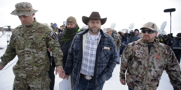 Ammon Bundy, center, one of the sons of Nevada rancher Cliven Bundy, walks off after speaking with reporters. Photo / AP