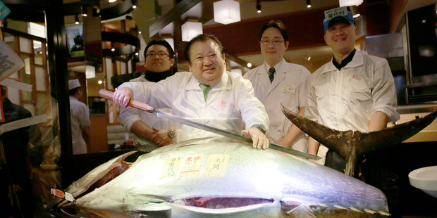 Kiyoshi Kimura, second from left, president of Kiyomura Co., poses a bluefin tuna at his Sushi Zanmai restaurant near Tsukiji fish market in Tokyo. Photo: AP photo/Eugene Hoshiko