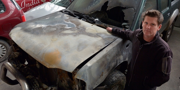 Richard Warrington with his burned-out Nissan Navara. Photo / Otago Daily Times