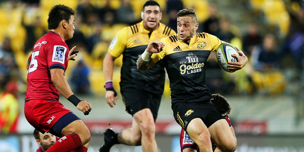 TJ Perenara of the Hurricanes looks to evade the challenge of Ayumu Goromaru. Photo / Getty Images