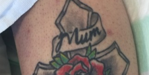 The woman has a tattoo of a cross with a rose, and has the words 'mum' and 'dad'. Photo / NZ Police