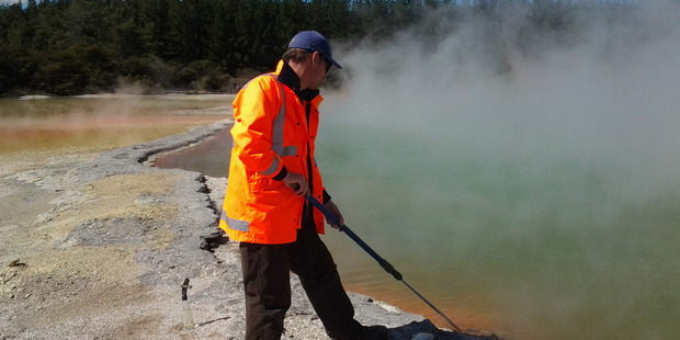 Matthew Stott takes samples from a geothermal area. Photo / Jean Power, GNS Science