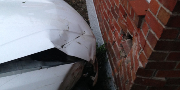 A white Nissan crashed into a house on Great North Rd in Waterview this morning. Photo / Jesse Bourke-Jackson