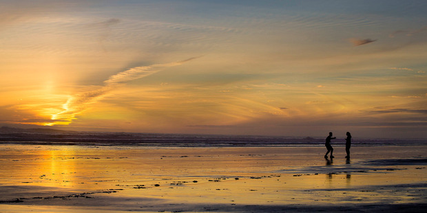 Two beachgoers make the most of the fine weather. Photo / Chris Loufte