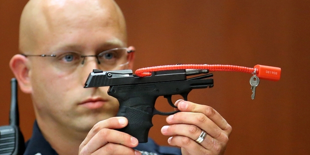 Sanford police officer Timothy Smith holds up the gun that was used to kill Trayvon Martin. Photo / AP