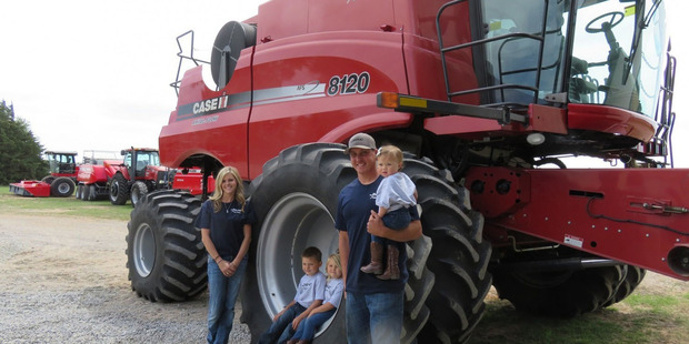 Jordan Hickel and his family stand next to their combine. Photo / Andrea Peterson, Washington