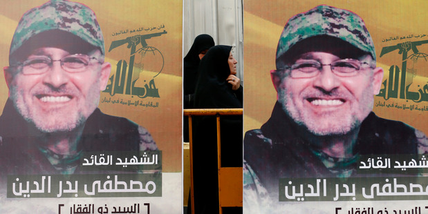 Pictures of slain top commander Mustafa Badreddine, who was killed in Syria, hang during his funeral procession in a southern suburb of Beirut, Lebanon. Photo / AP