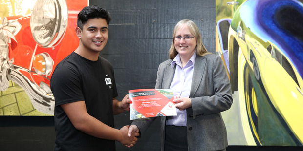 Heremia White accepts a scholarship to study at Waiariki Bay of Plenty Polytechnic from then-Waiariki chief executive Prof Margaret Noble. Photo/Supplied