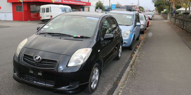 Queen St business-owners are tired of unlicensed, imported vehicles parked on the street. The cars are taking up all the parking spaces, leaving nowhere for customers to park. PHOTO/HAYLEY GASTMEIER