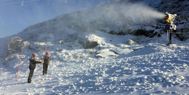 Coronet Peak snow-making team members Jake Reilly (left) and Lucy Ruck measure the snow on the ski area yesterday. Photo / Supplied via NZSKI