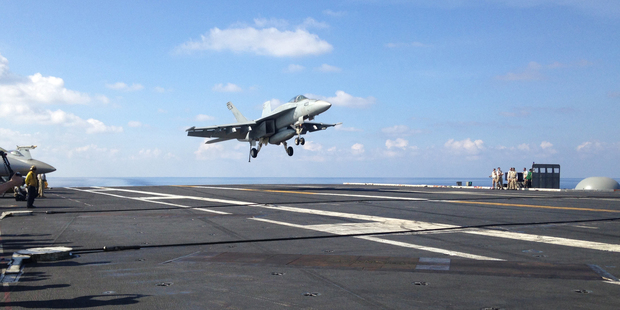 An FA-18 jet fighter lands on the USS John C. Stennis aircraft carrier in the South China Sea. Photo / AP