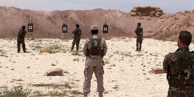 Syrian Arab trainees practice firing their small arms at an undisclosed training range in northern Syria. Photo / AP