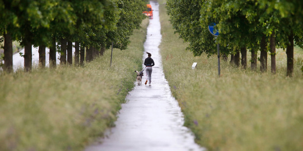 A woman runs with her dog in Frankfurt, Germany. The Government is adopting a carrot and stick approach to refugees. Photo / AP