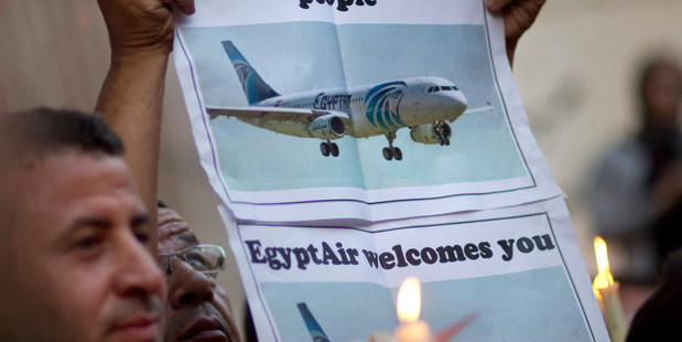 An Egyptian journalist holds a candle and a poster supporting EgyptAir during a candlelight vigil for the victims of MS804 in Cairo. Photo / AP