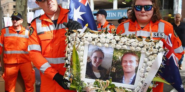 SES Volunteers carefully carry away a photo tribute of Katrina Dawson and Tori Johnson, the two victims of the Lindt Cafe seige. Photo / Getty