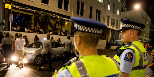 Sergeant Rod Sue, left and Constable Tony Foster watch outside 1885 bar on Galway Street. Photo / Mike Scott