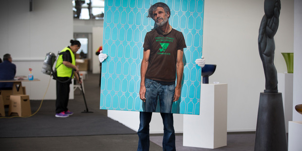 Jonathan Gooderham, managing director of Artis Gallery, holds Liam Barr's oil painting David as gallerists set up for the art fair at The Cloud. Photo / Brett Phibbs