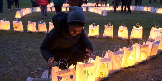 Maria Lyne, a teacher from Levin's St Joseph's School, viewing candle-lit paper bags during the vigil at the Waitarere Domain. Photo / Mark Mitchell