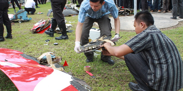 Investigators examine debris from a Qantas jet that suffered engine failure over the Indonesian island of Batam. Photo / Getty Images